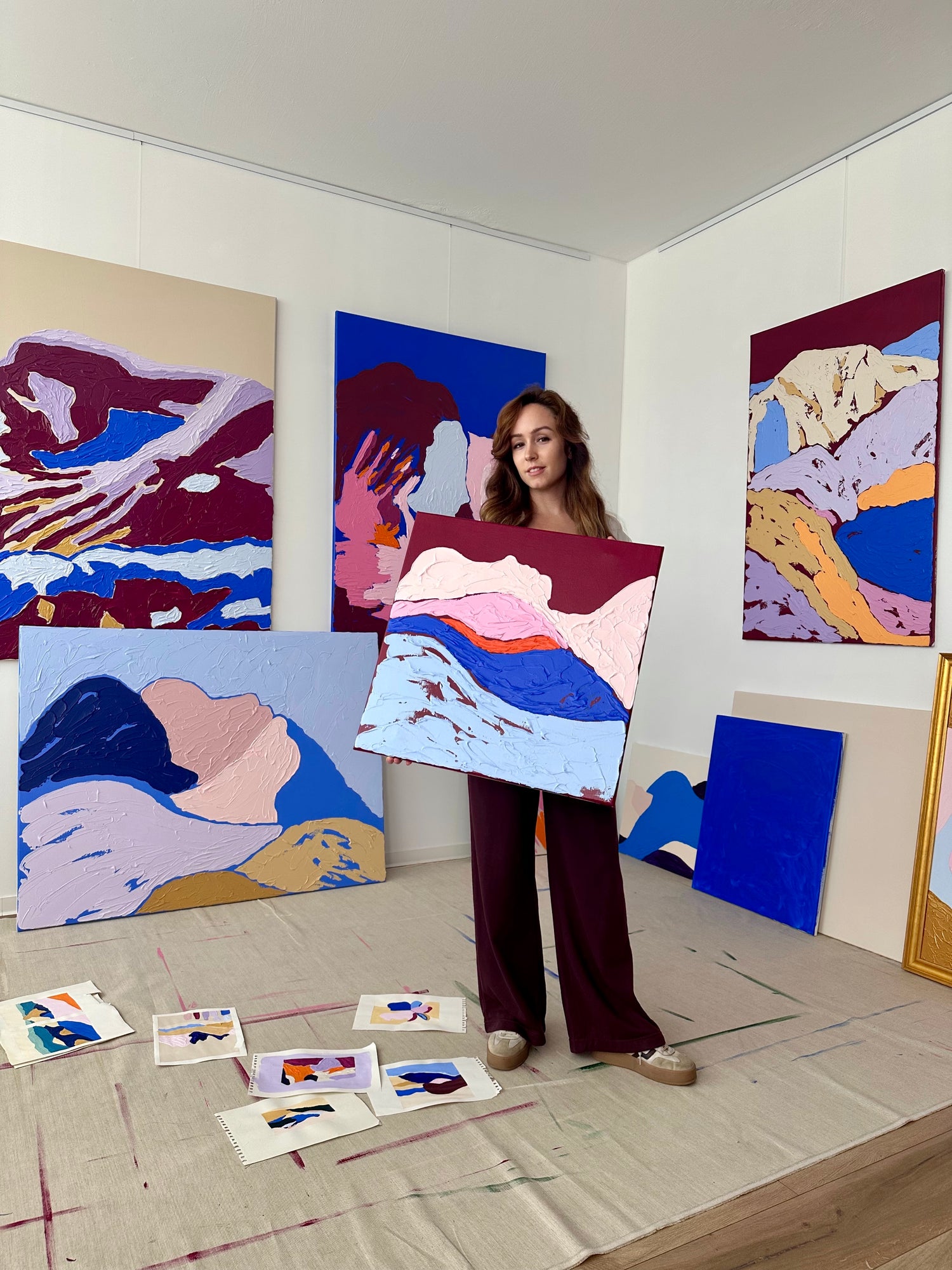 Art of Meka – contemporary abstract artist presenting a textured thick-paint mountain painting in her studio, modern acrylic artwork in bold color palette